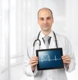 Doctor holding a tablet showing a graph and a heart