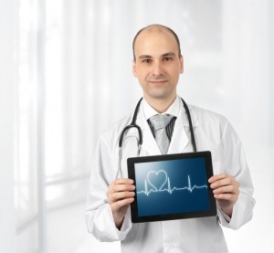 Doctor holding a tablet showing a graph and a heart